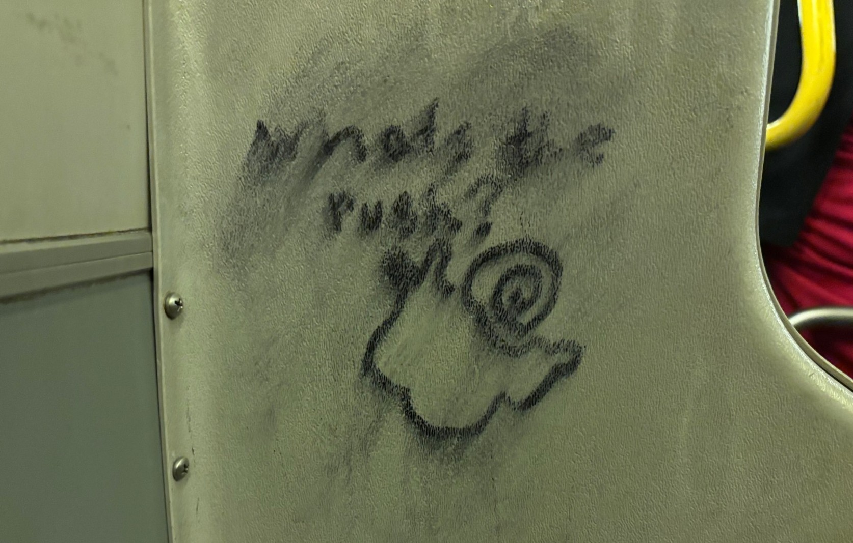 Graffiti on a bus depicting a snail with the caption asking "what's the rush?"